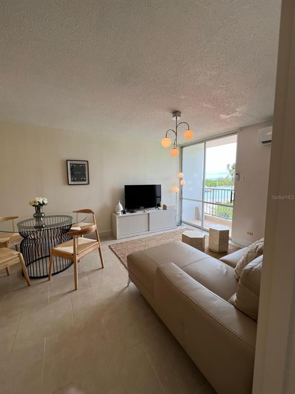 A living and dining area features tile floors, a glass table, and a beige sofa — Tower 1 ISLETA MARINA UNIT 4C, FAJARDO, PR