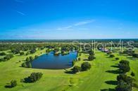 An aerial view of a golf course featuring a large pond surrounded by green grass — 304 ORCHID DRIVE, INDIAN LAKE ESTATES, FL