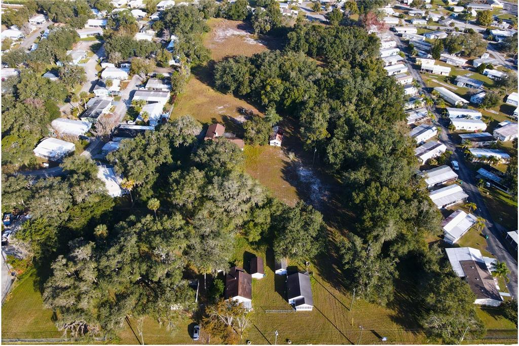 An aerial view shows a large, wooded residential lot with several houses and outbuildings — 4011 S ORANGE BLOSSOM TRAIL, KISSIMMEE, FL