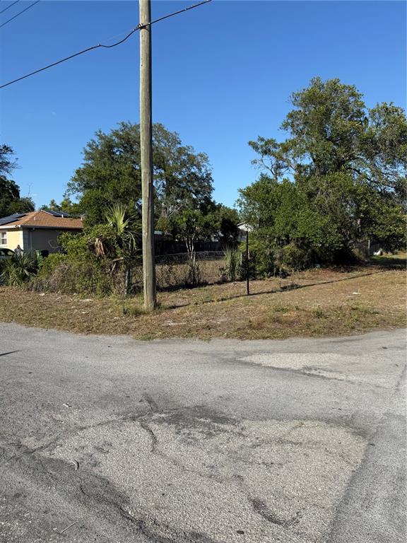 A vacant, grassy residential lot sits at a street corner next to a house — 3601 N GARRISON STREET, TAMPA, FL