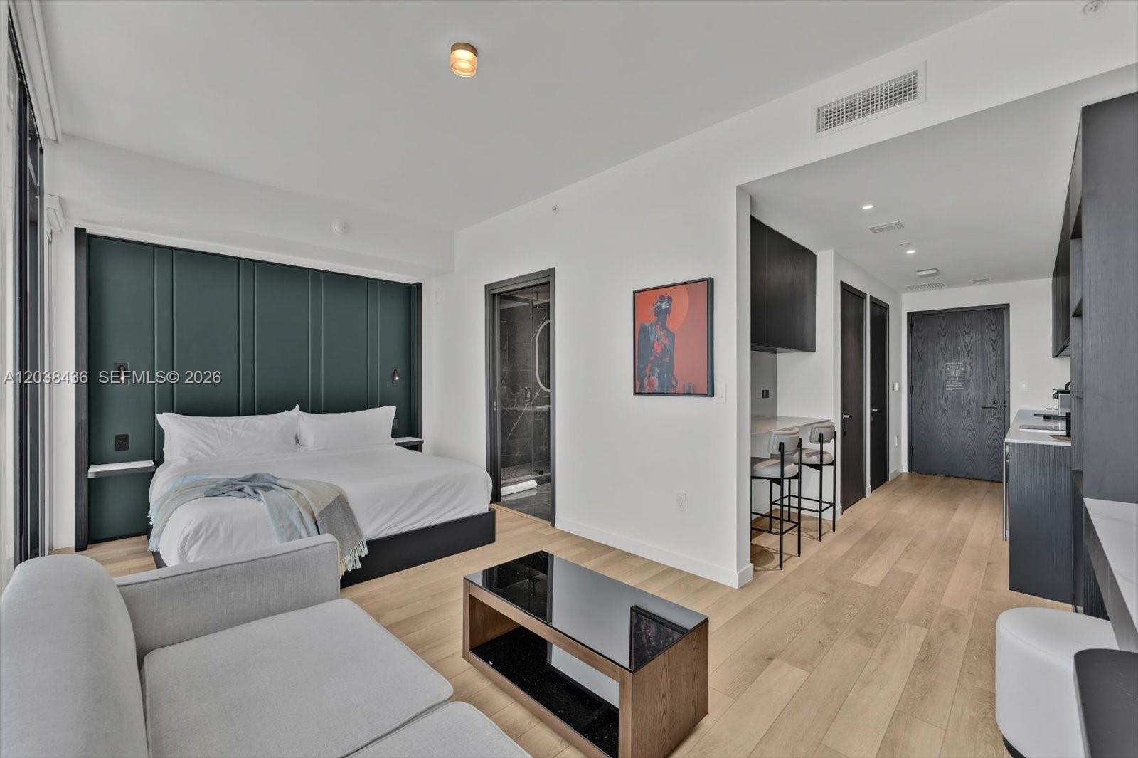A modern studio apartment features a bed, a small kitchenette, and light wood flooring — 20 NE 11th St # 3105, Miami FL 33132, MIAMI, FL