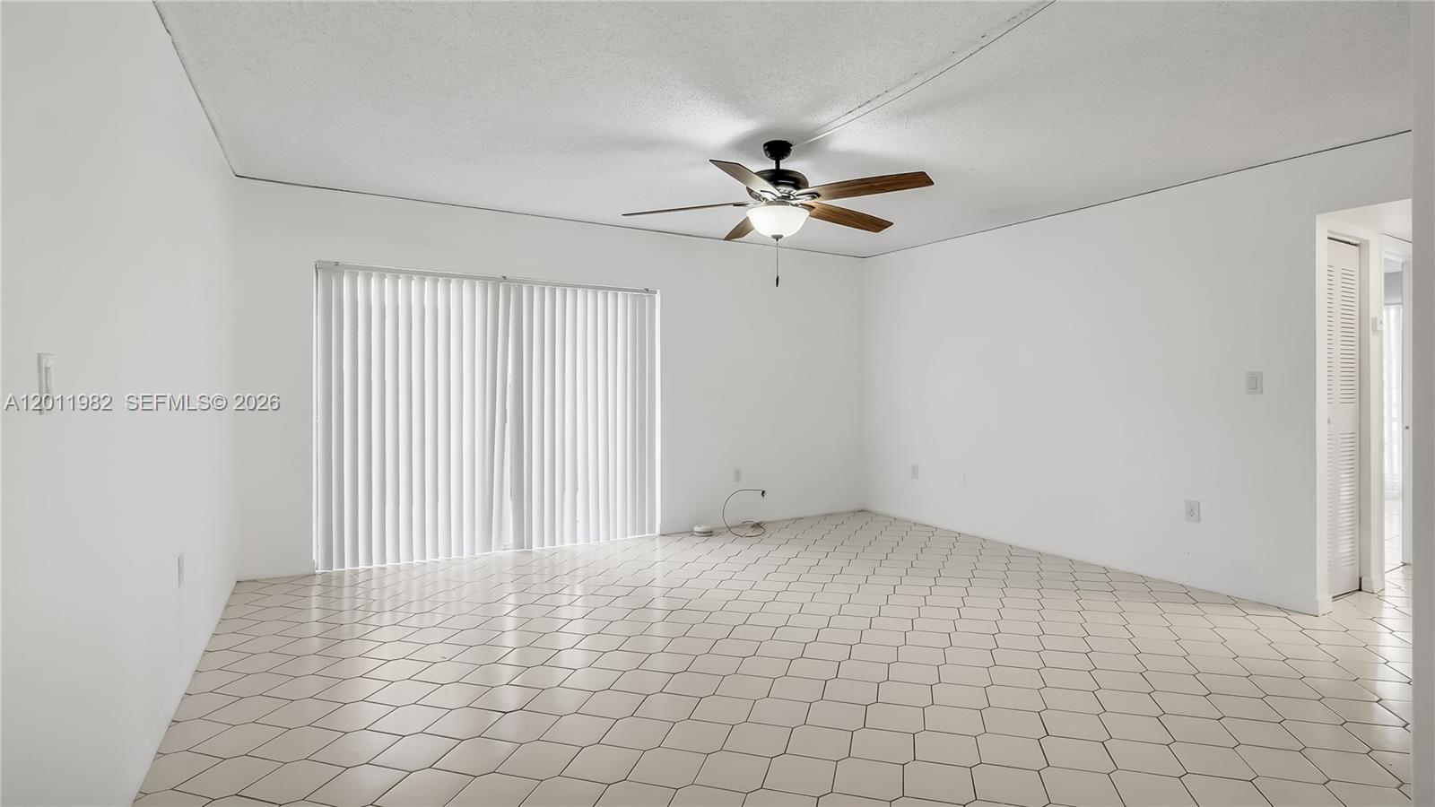 An empty room features white walls, a ceiling fan, and light-colored hexagonal floor tiles — 7231 Miami Lakes Dr # C5, Miami Lakes FL 33014, MIAMI LAKES, FL