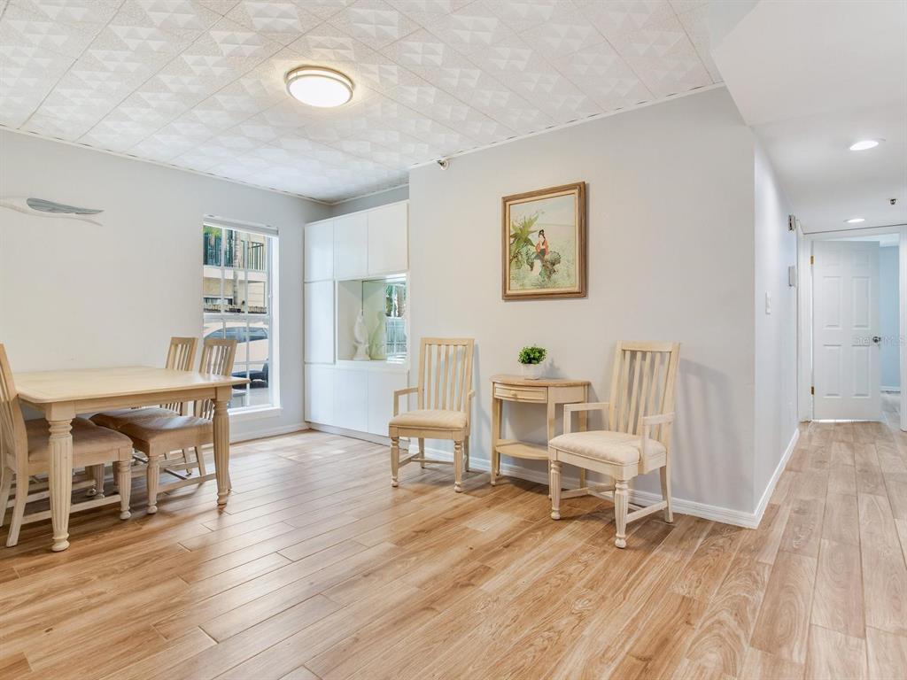 A dining area with light wood flooring, a white table, and four chairs — 508 S GLEN AVENUE UNIT 2, TAMPA, FL