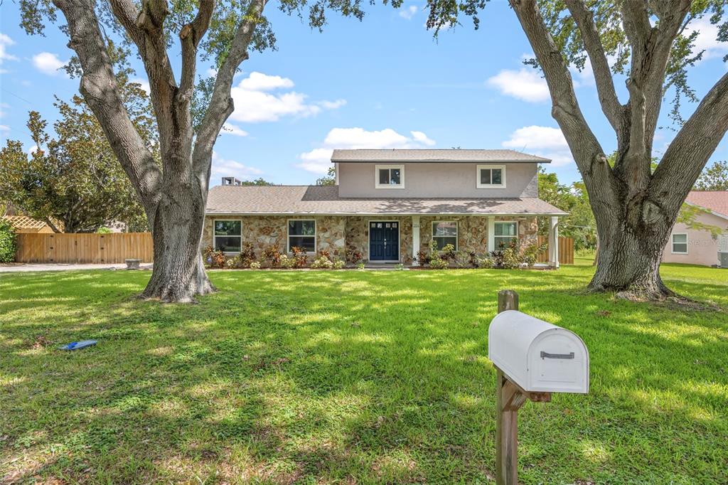 A two-story house with a stone facade and a white mailbox in the front yard — 204 YORK DRIVE, COCOA, FL