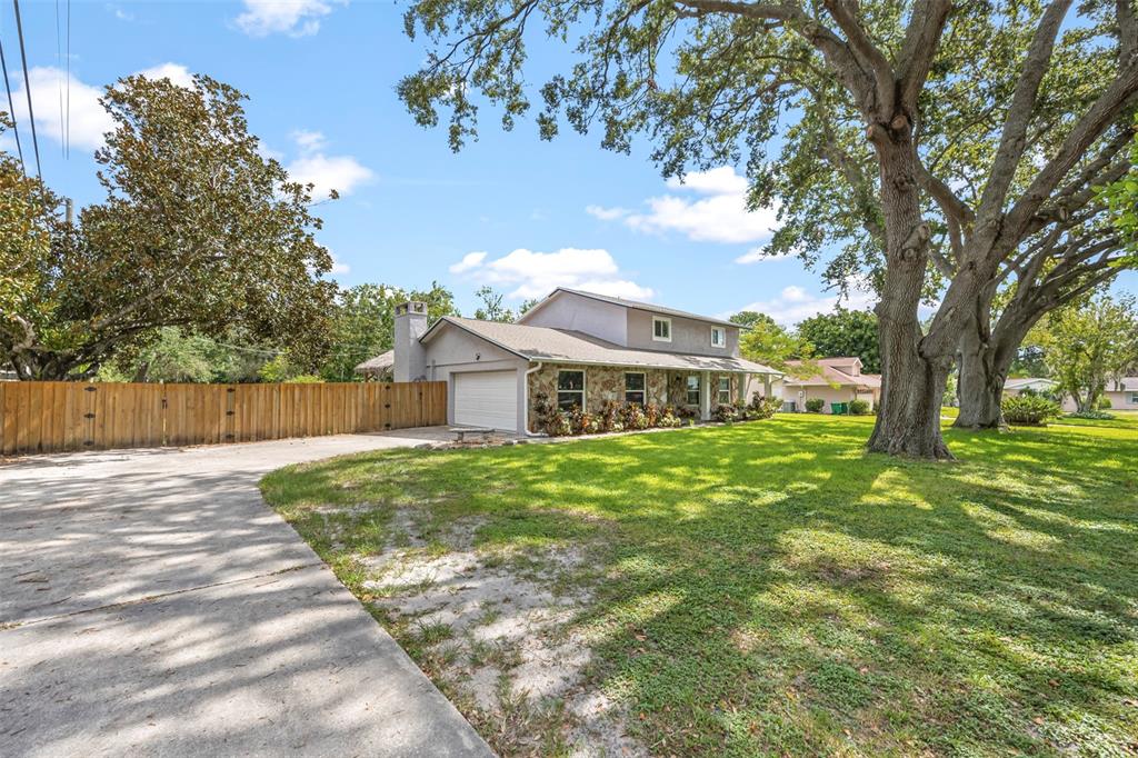 A two-story house with a stone facade, attached garage, and a large front yard — 204 YORK DRIVE, COCOA, FL