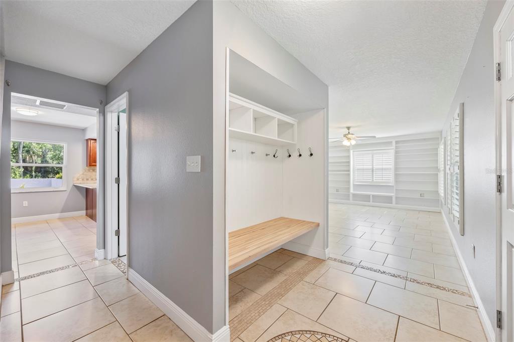 A hallway features a built-in mudroom bench with storage cubbies and tile flooring throughout — 204 YORK DRIVE, COCOA, FL