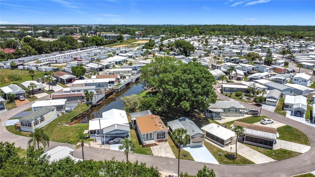 An aerial view shows a mobile home community with a central canal and mature trees — 9000 US HIGHWAY 192 UNIT 155, CLERMONT, FL