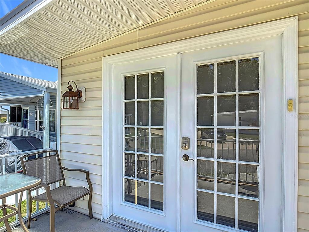 A white double door with glass panes is set into the beige vinyl-sided exterior wall — 9000 US HIGHWAY 192 UNIT 155, CLERMONT, FL