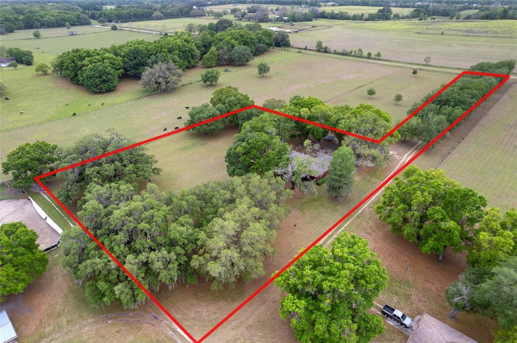 An aerial view shows a house surrounded by trees and pasture land outlined in red — 3149 SW 200TH AVENUE, DUNNELLON, FL