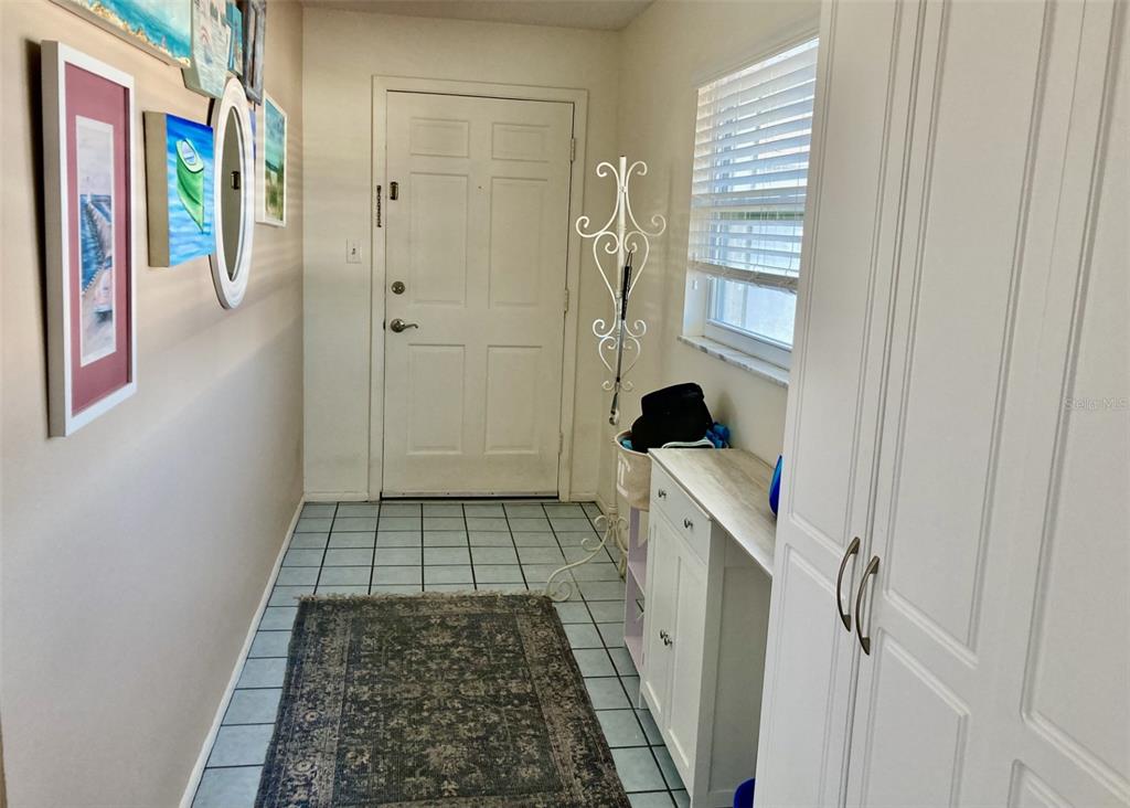 An entryway features a tiled floor, a white front door, and a wall gallery — 304 47TH AVENUE DRIVE W UNIT 307, BRADENTON, FL