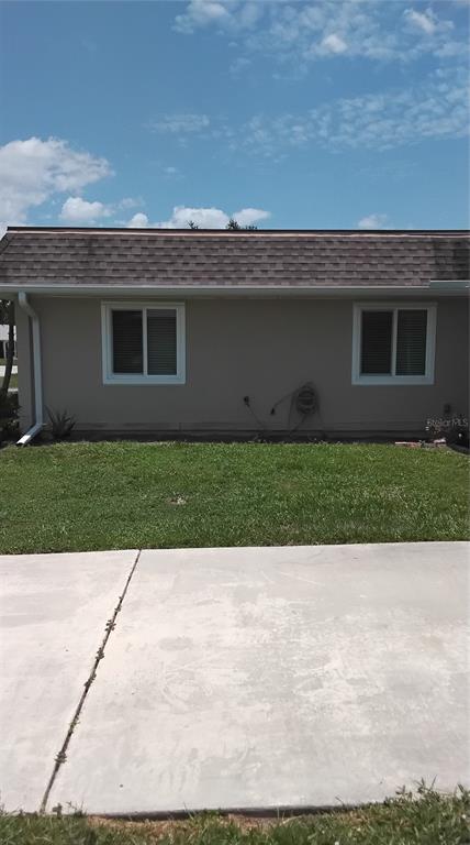 A living room features tile flooring, a gray sofa, a recliner, and a kitchen island — 18579 ROBINSON AVENUE, PORT CHARLOTTE, FL