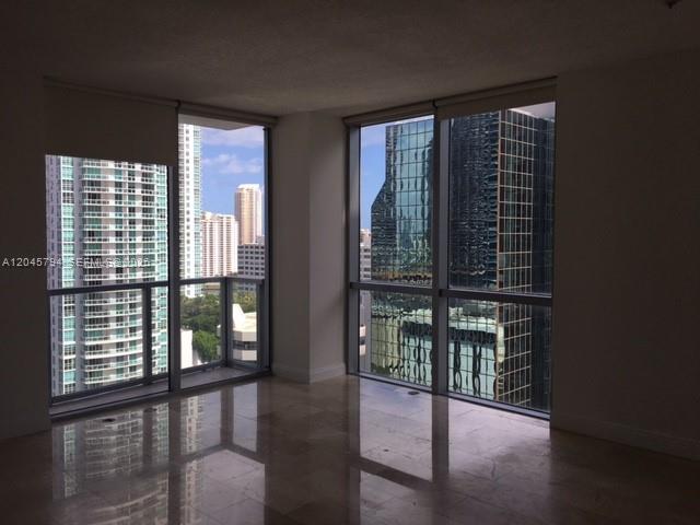 An empty room with floor-to-ceiling windows and polished stone floors overlooking city skyscrapers — 1060 BRICKELL AV # 1901, Miami FL 33131, MIAMI, FL