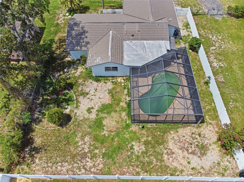 An aerial view shows a single-story house with a driveway, palm trees, and backyard — 13438 BRIGHTON STREET, SPRING HILL, FL