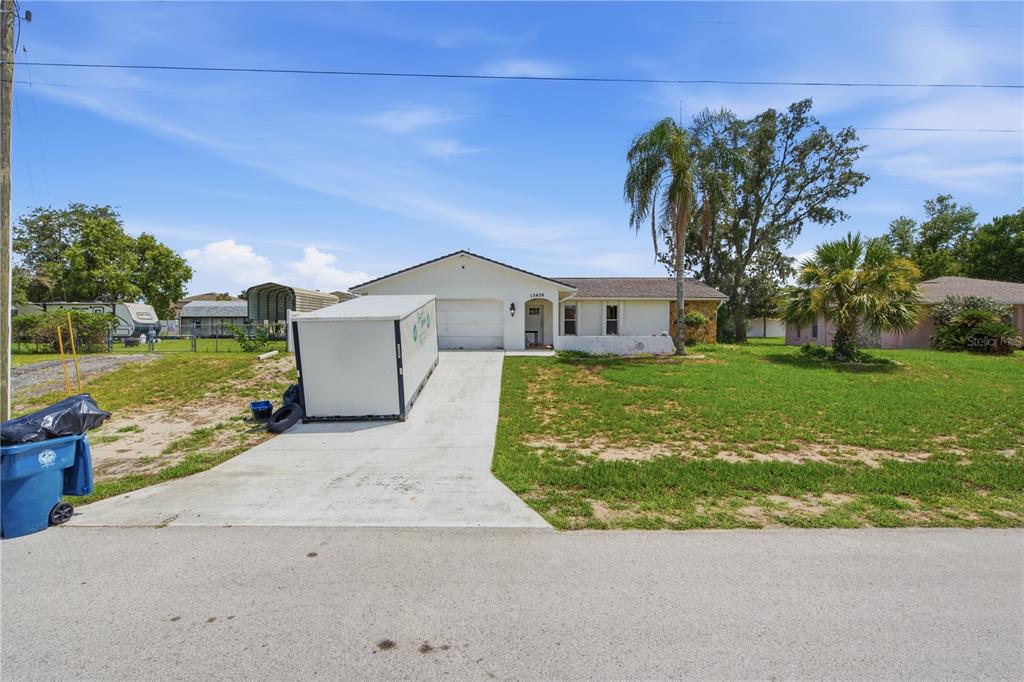 An aerial view shows a single-story house with a concrete driveway and a fenced backyard — 13438 BRIGHTON STREET, SPRING HILL, FL