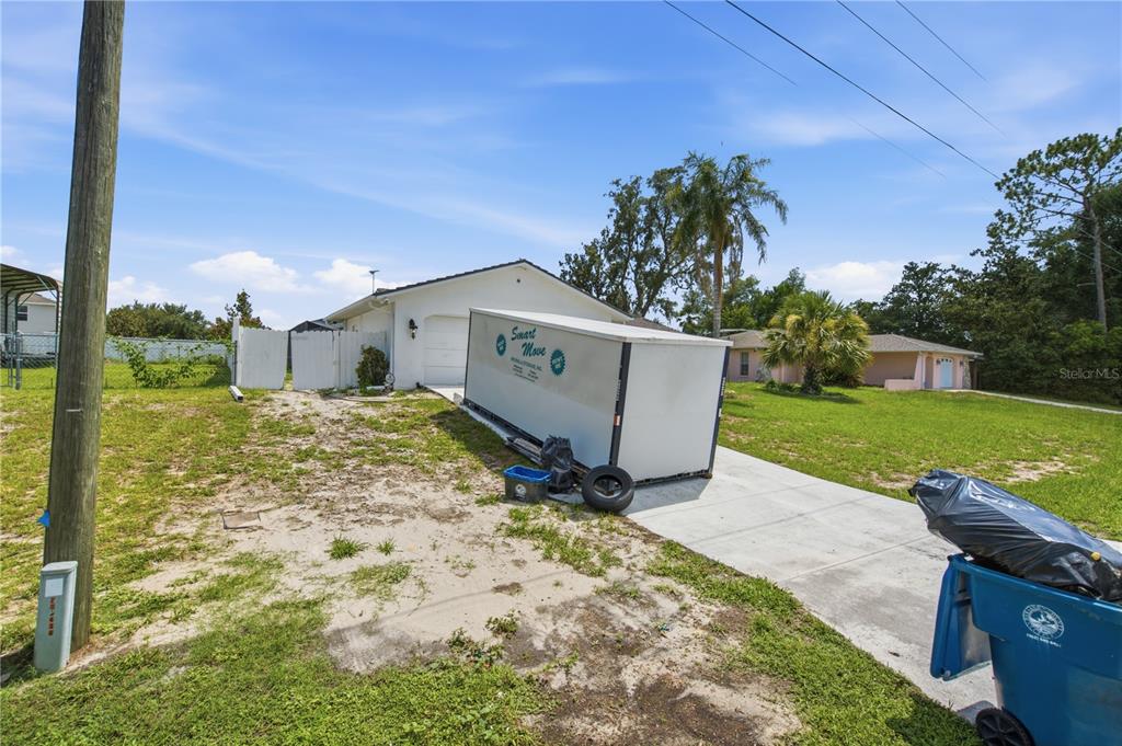 A bedroom features light gray walls, wood-look flooring, a ceiling fan, and two doorways — 13438 BRIGHTON STREET, SPRING HILL, FL
