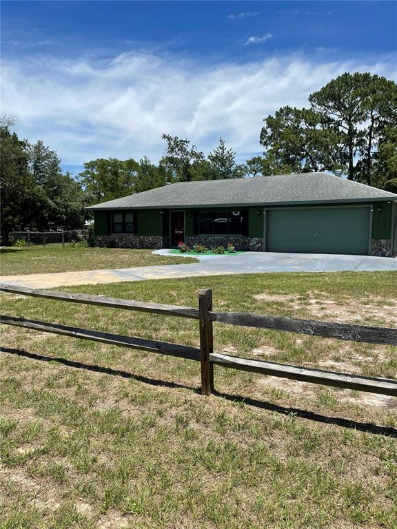 A single-story house with green siding, a stone base, and an attached garage — 7223 S SESAME STREET TERRACE, HOMOSASSA, FL