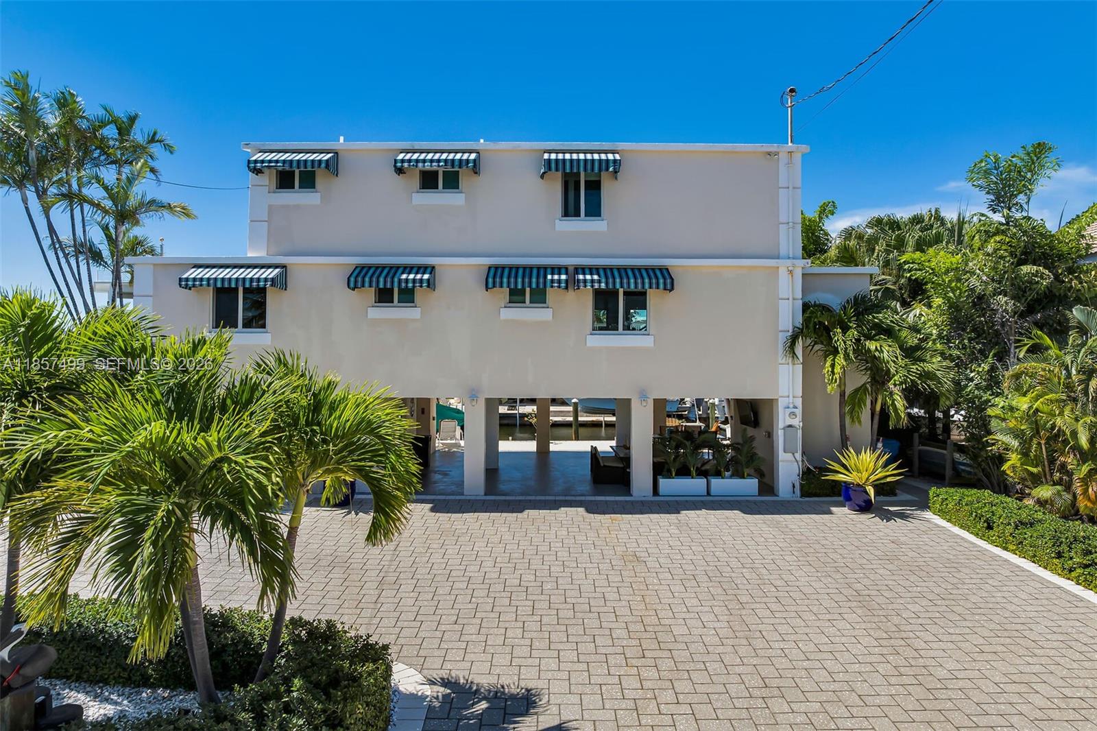An aerial view shows a waterfront house with a boat dock and canal — 122 Court Contessa, Islamorada FL 33036, ISLAMORADA, FL