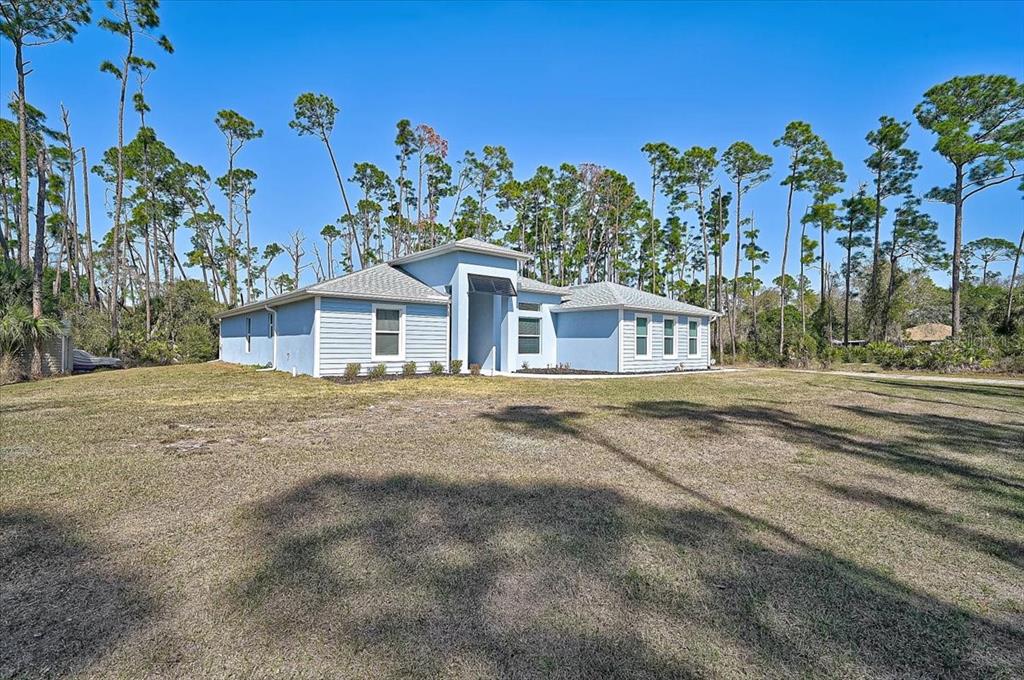 A light blue, single-story house with a prominent entryway stands on a large, grassy lot — 4109 N CRANBERRY BOULEVARD, NORTH PORT, FL