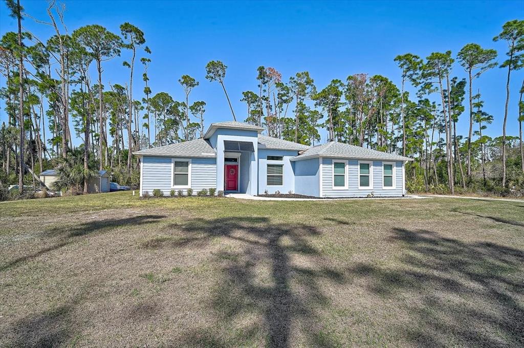 A light blue single-story house with a red front door sits on a grassy lot — 4109 N CRANBERRY BOULEVARD, NORTH PORT, FL