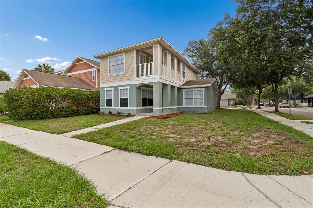 A two-story house with a green lower level, tan upper level, and a front balcony — 3801 MACHADO STREET, TAMPA, FL