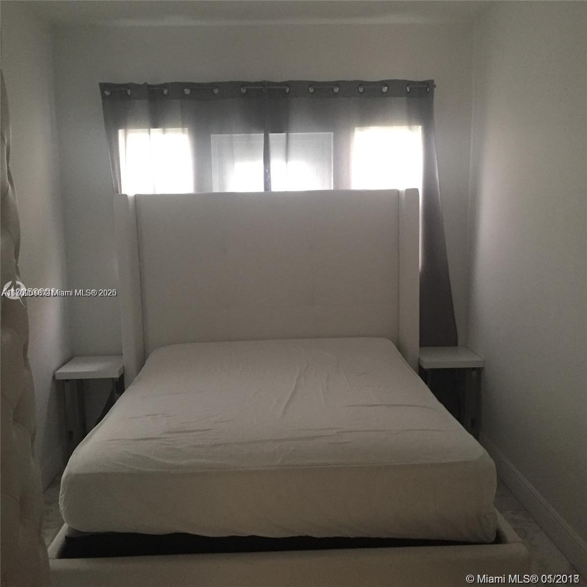 A bedroom features a white upholstered bed frame and headboard between two small side tables — 918 Jefferson Ave # 2, Miami Beach FL 33139, MIAMI BEACH, FL
