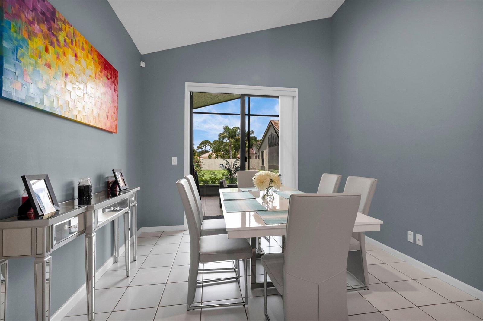 A dining room features a white table, gray chairs, a mirrored console, and sliding glass doors — 10393 Lexington Circle S, Boynton Beach FL 33436, BOYNTON BEACH, FL