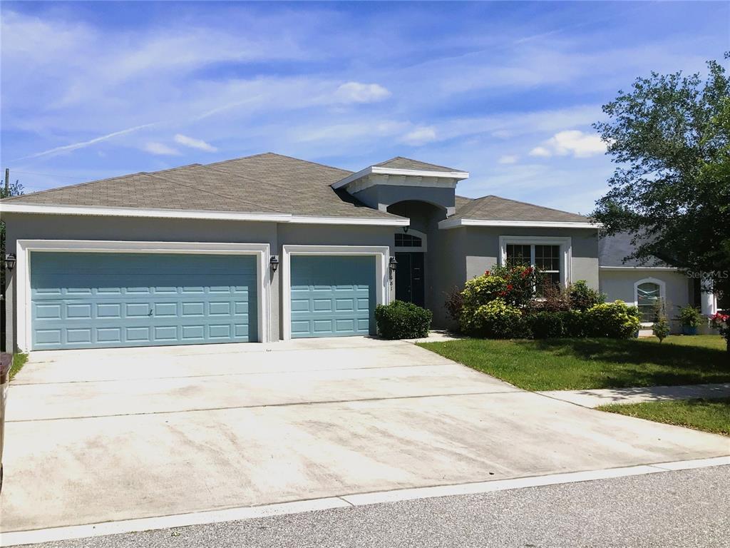A gray single-story house features a two-car garage, a covered entryway, and a concrete driveway — 481 PHEASANT DRIVE, HAINES CITY, FL