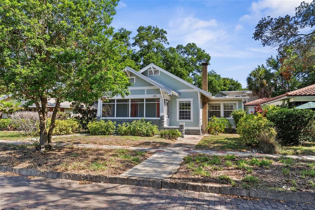 A light blue bungalow with a screened front porch and a brick chimney — 205 12TH AVENUE N, ST PETERSBURG, FL