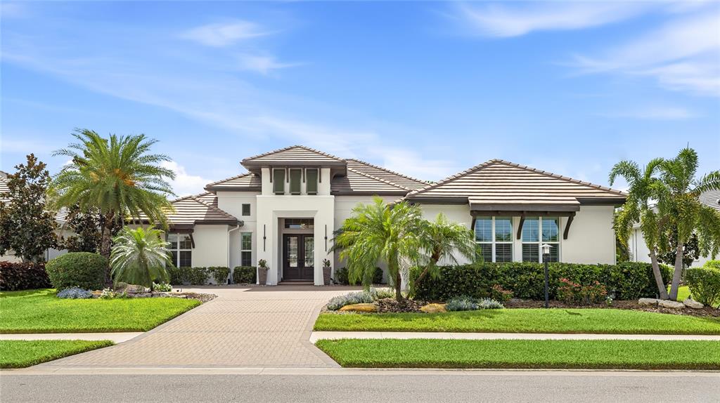 A single-story house with a tiled roof, white stucco exterior, and a paved driveway — 804 CROSSWIND AVENUE, SARASOTA, FL