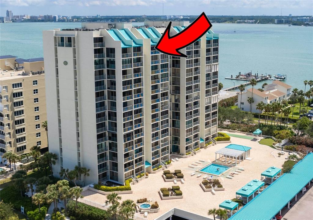 An aerial view of a beachfront high-rise condominium building with a pool and patio area — 1390 GULF BOULEVARD UNIT PH-3, CLEARWATER BEACH, FL