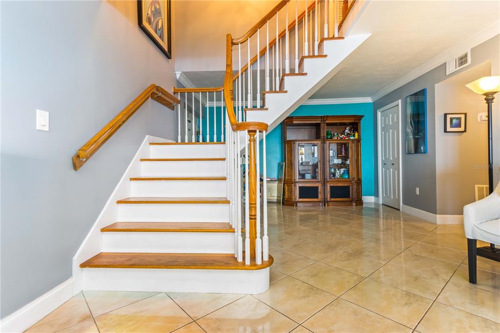 An aerial view shows a tall residential building with balconies overlooking a pool and bay — 1390 GULF BOULEVARD UNIT PH-3, CLEARWATER BEACH, FL
