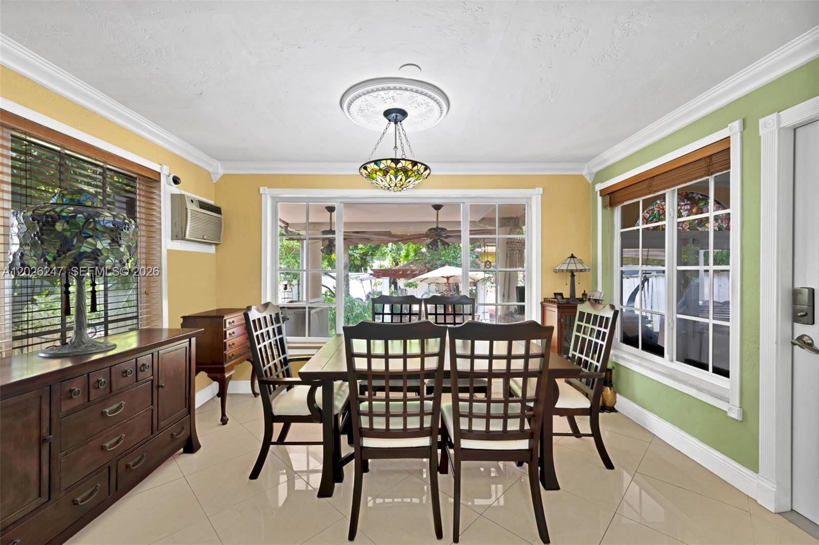 A dining room features a wooden table, chairs, tile flooring, and a stained-glass chandelier — 2849 Dewey St # 2849, Hollywood FL 33020, HOLLYWOOD, FL