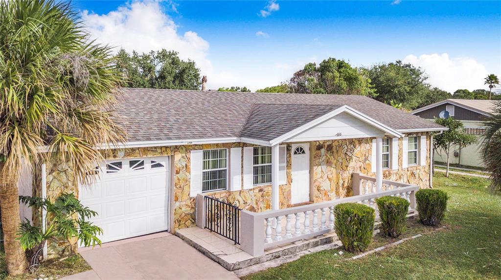 A single-story house with a stone facade, a white garage door, and a front porch — 666 FLORIDA PARKWAY, KISSIMMEE, FL