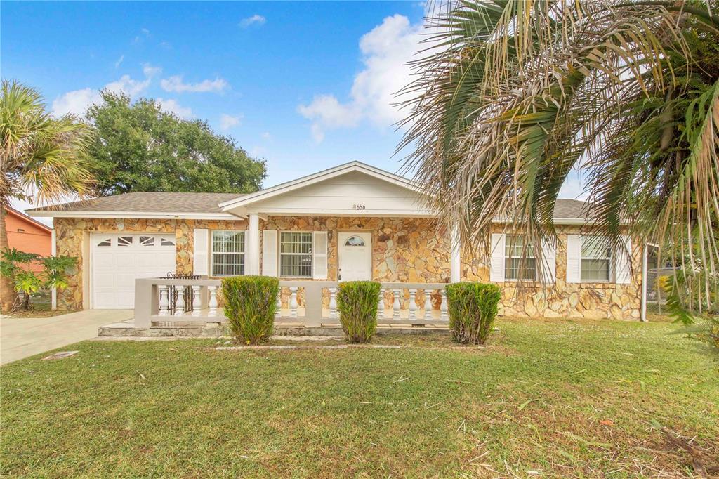 A single-story house with a stone facade, a front porch, and a one-car garage — 666 FLORIDA PARKWAY, KISSIMMEE, FL