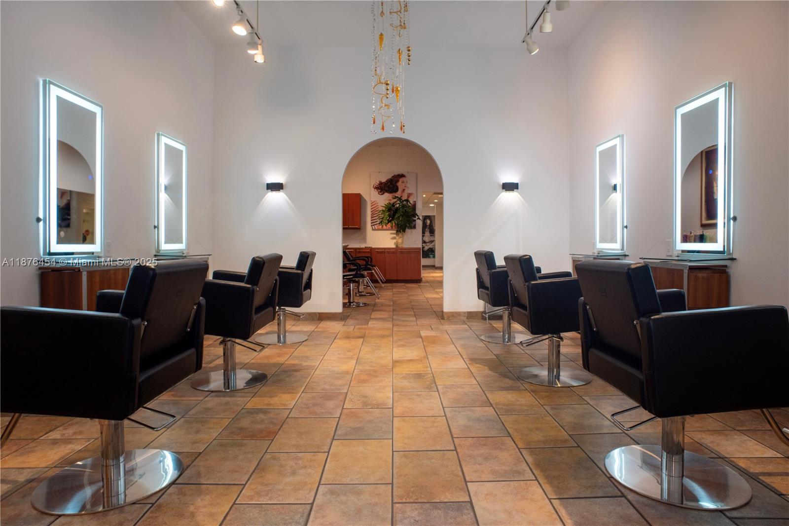 A hair salon features four black styling chairs, illuminated wall mirrors, and tiled flooring — 345 MIRACLE MILE, Coral Gables FL 33134, CORAL GABLES, FL