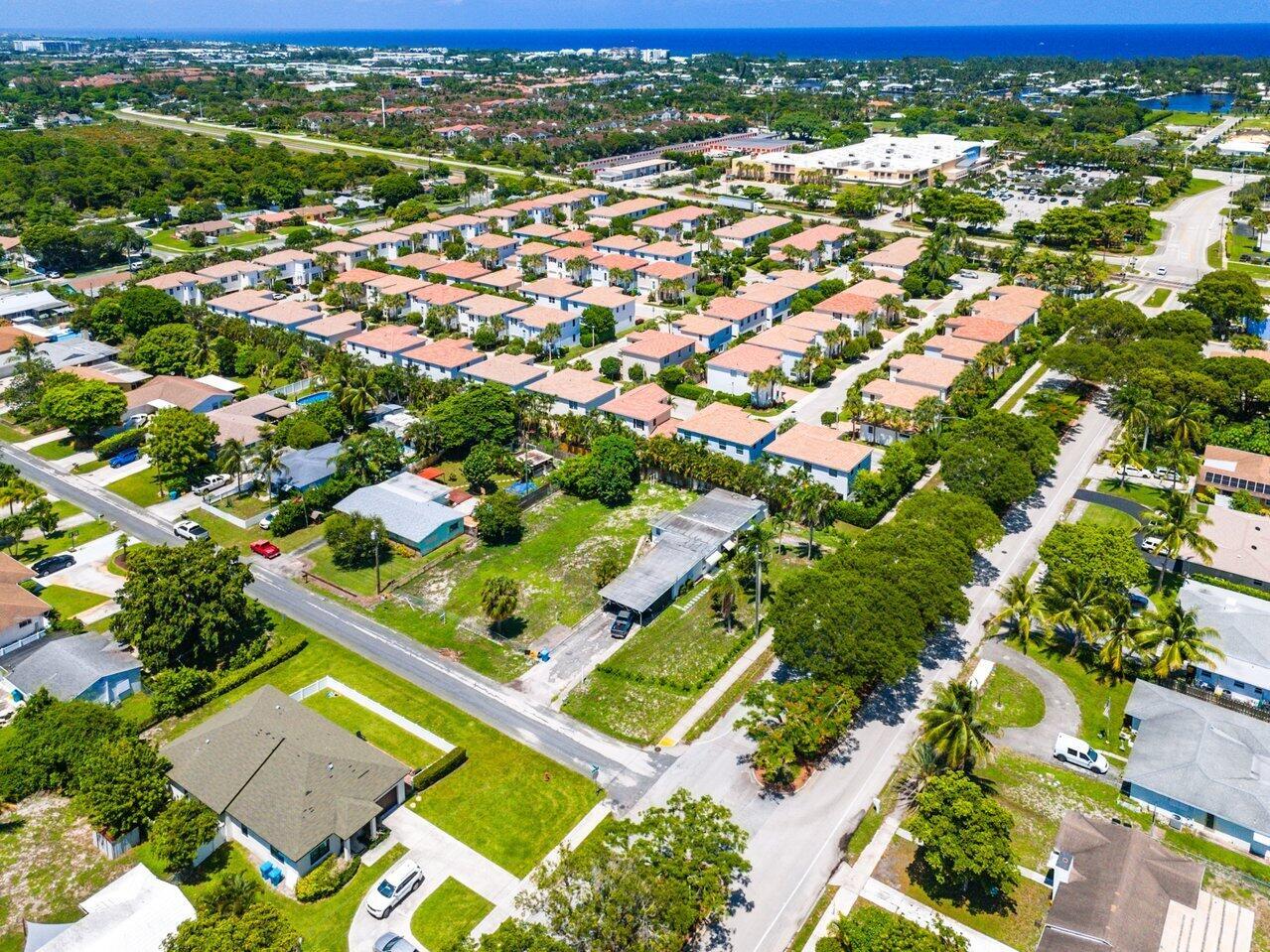 An aerial view shows a residential neighborhood with many houses, green trees, and paved streets — 3650 SE 2nd Court, Boynton Beach FL 33435, BOYNTON BEACH, FL