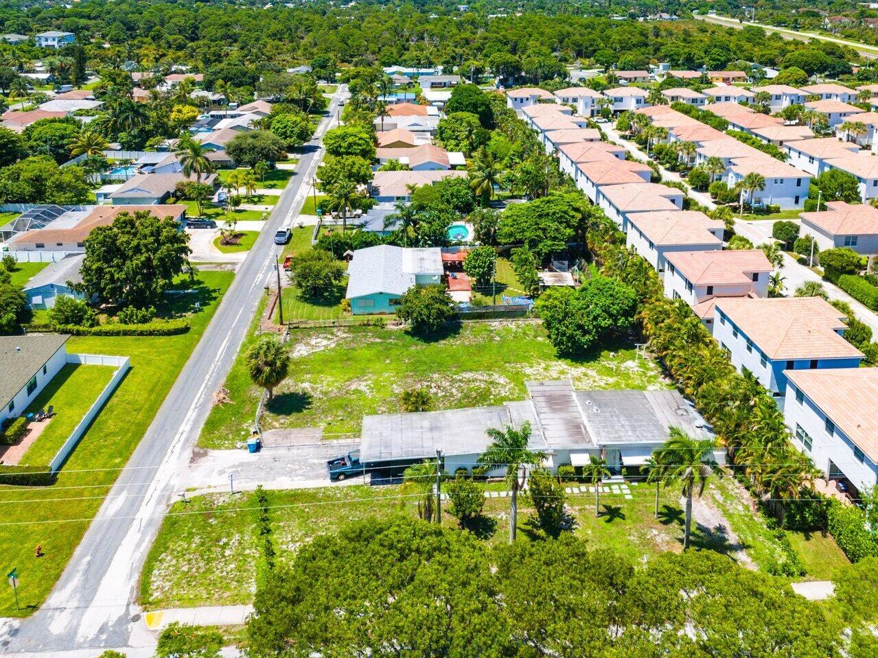 An aerial view of a suburban neighborhood featuring residential houses, palm trees, and paved streets — 3650 SE 2nd Court, Boynton Beach FL 33435, BOYNTON BEACH, FL