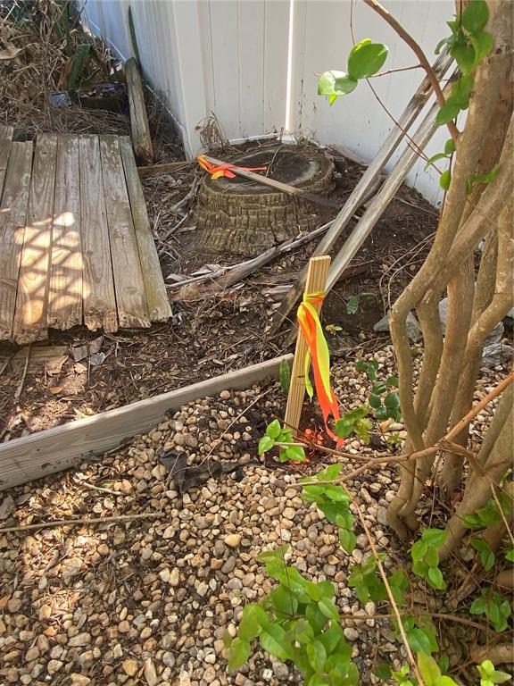A wooden stake with orange and yellow ribbons stands in a gravel yard near a stump — 121 13TH AVENUE, INDIAN ROCKS BEACH, FL