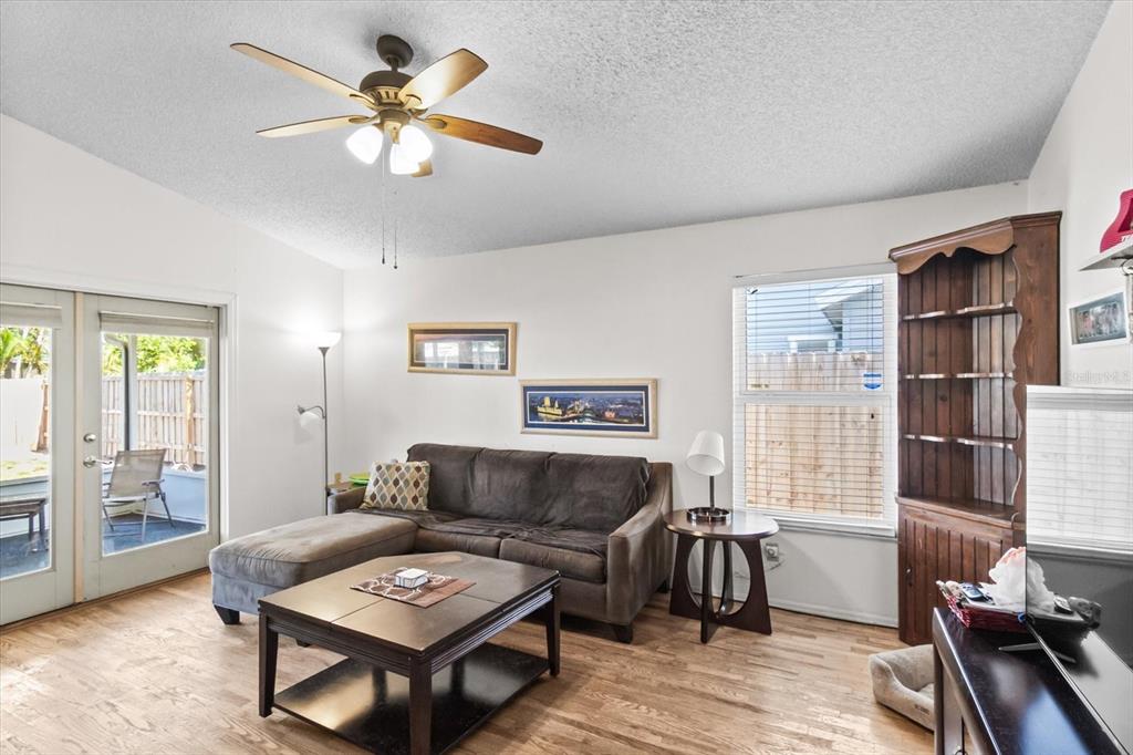A living room features a sectional sofa, coffee table, ceiling fan, and hardwood flooring — 1219 MACKERAL AVENUE, SARASOTA, FL