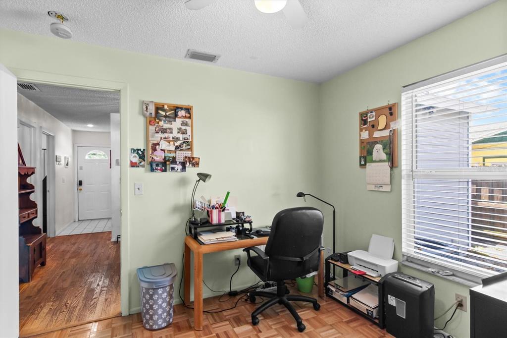 A home office with light green walls, a wooden desk, and a window with blinds — 1219 MACKERAL AVENUE, SARASOTA, FL
