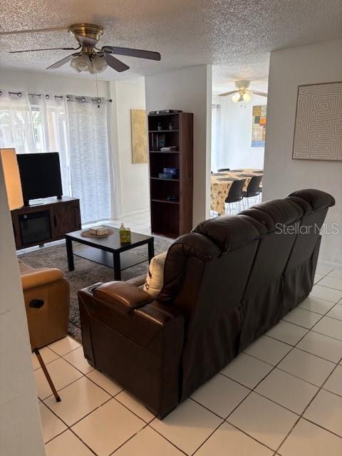 A living room features a brown leather sofa, a coffee table, and a tall bookshelf — 2625 STATE ROAD 590 UNIT 2413, CLEARWATER, FL
