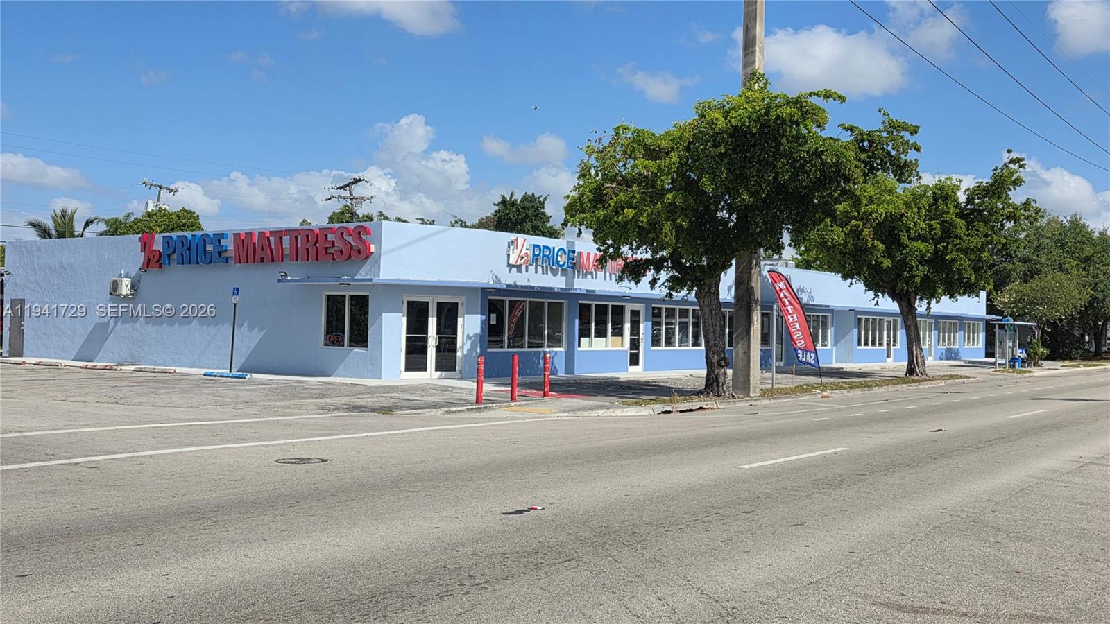 A light blue commercial building with red signage sits along a paved road — 13914 NW 7th Ave, Miami FL 33168, MIAMI, FL