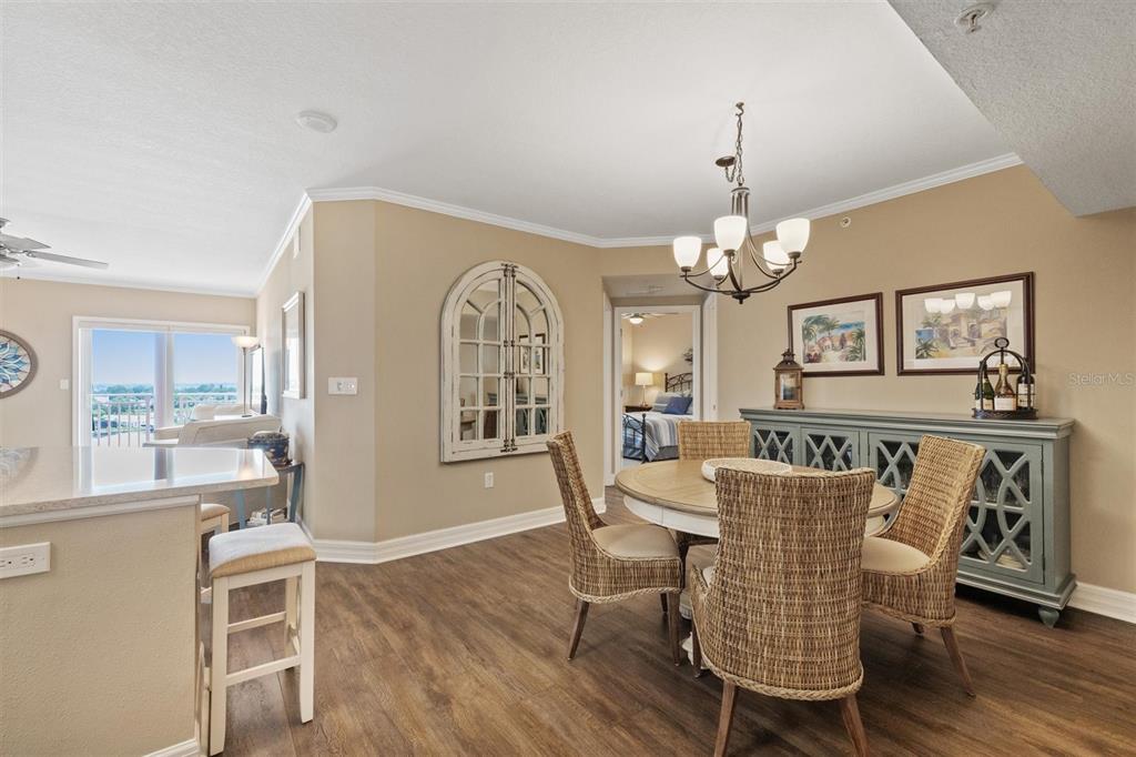 A dining area features a round table with wicker chairs, a sideboard, and a chandelier — 4516 SEAGULL DRIVE UNIT 804, NEW PORT RICHEY, FL