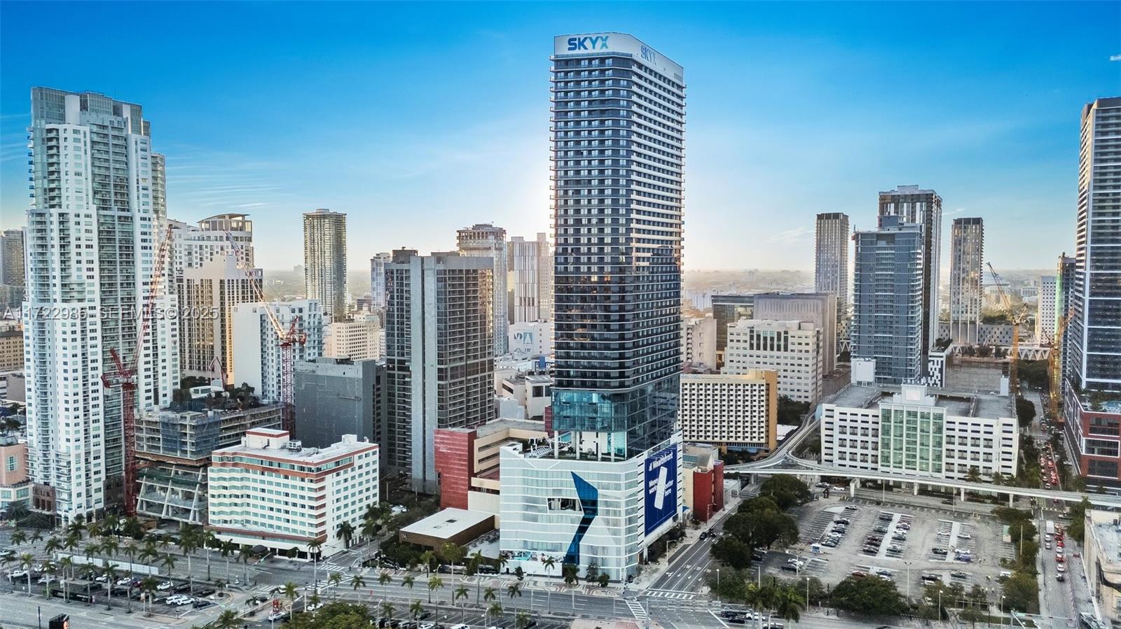 An aerial view of a modern skyscraper and surrounding urban buildings in a city skyline — 398 NE 5th St # 3209, Miami FL 33132, MIAMI, FL