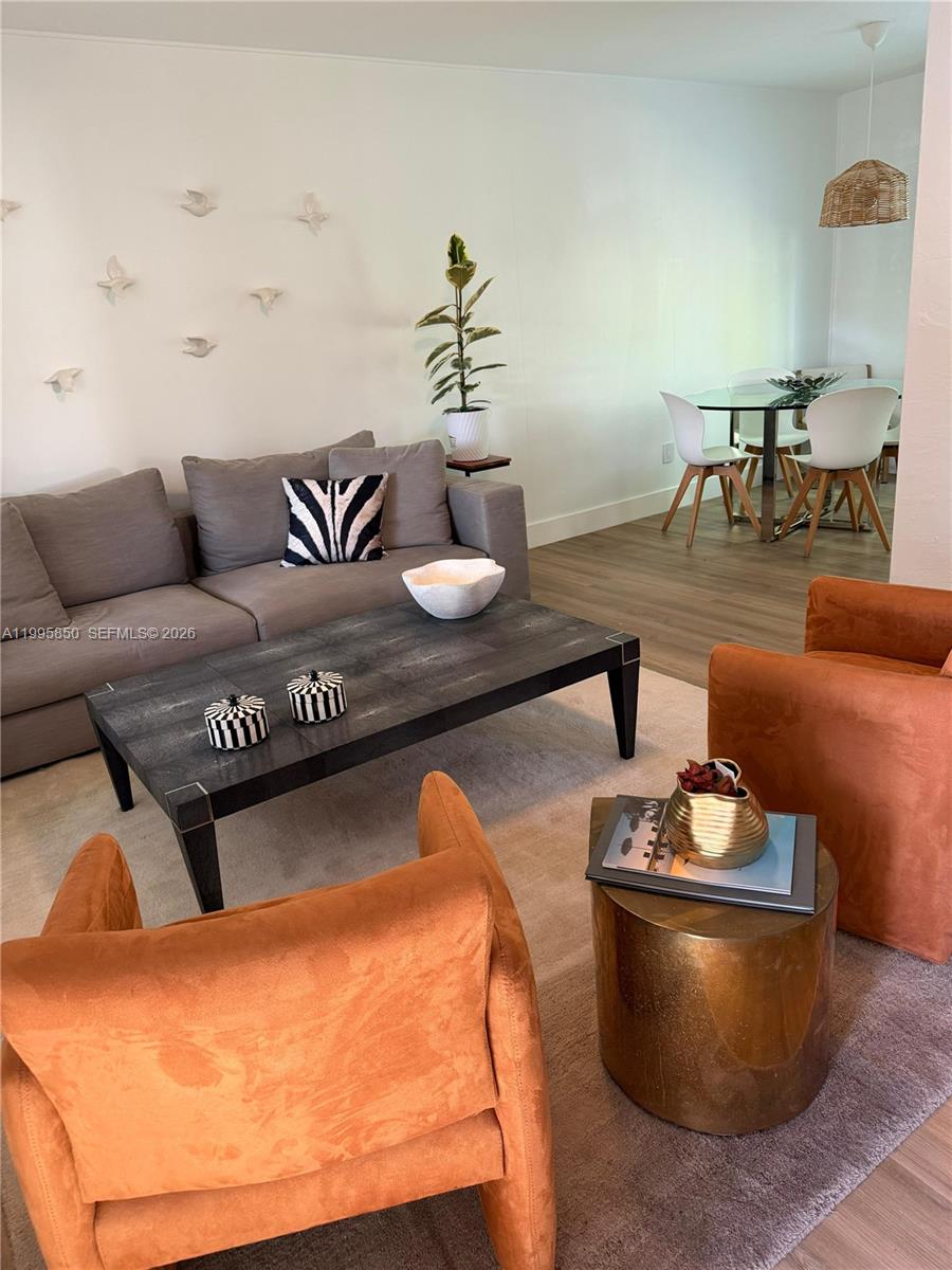 A living room features a grey sofa, two orange armchairs, and a dark coffee table — 11201 NE 10th Ave # 11201, Biscayne Park FL 33161, BISCAYNE PARK, FL