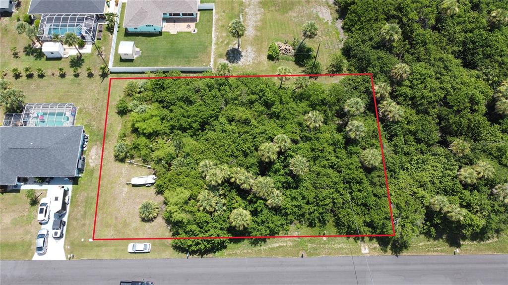 An aerial view shows a rectangular, wooded vacant lot outlined in red next to residential houses — 4501 EWING CIRCLE, PORT CHARLOTTE, FL