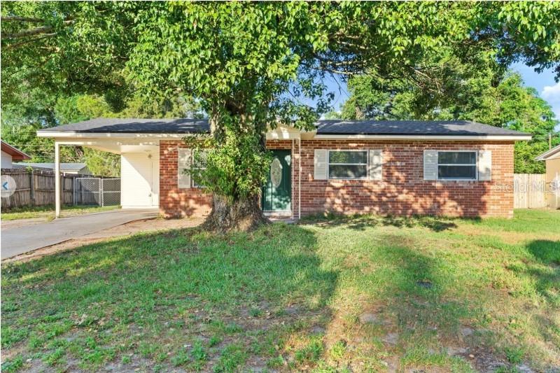 A single-story brick house features a front carport and a large tree in the yard — 3544 COLLEEN DRIVE, LAKELAND, FL