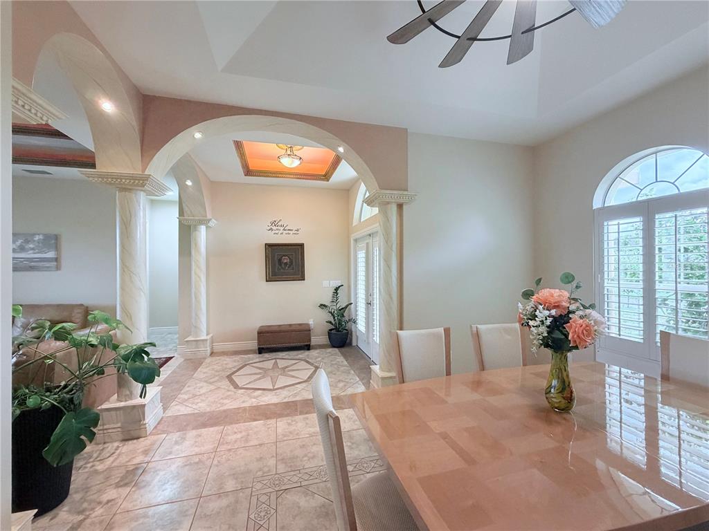 A dining room features a wooden table, six chairs, arched windows with shutters, and columns — 324 SANTURCE AVENUE, NORTH PORT, FL