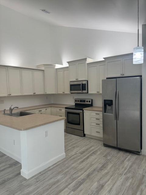 A kitchen features white cabinets, stainless steel appliances, and a light-colored countertop island — 1171 Summit Trail Circle # C, West Palm Beach FL 33415, WEST PALM BEACH, FL
