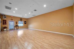 An empty room with light wood-look flooring, tan walls, and recessed ceiling lighting — 2625 KEYSTONE ROAD UNIT 2, TARPON SPRINGS, FL